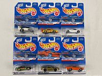 Front view of six Hot Wheels 1998 First Editions die-cast cars sealed in original packaging, showing various car models and colors.