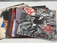 Stack of 8 vinyl LP record albums showing top sides with visible cover art for Hall & Oates, Chris de Burgh, and others
