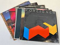 Front view of vinyl albums stacked showing Foreigner Agent Provocateur at front