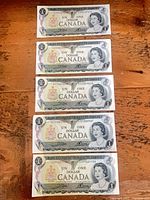 Five 1973 $1 Canadian banknotes laid flat obverse side