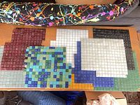 Assorted colour glass mosaic sheets spread on table