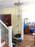 Full view of hanging mobile showing cast-metal top and dangling chains with charms