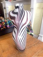 Front view of torso-shaped vase showing zebra stripe pattern and overall form