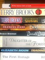 Spine view of seven advance reader copy books