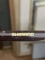 Close-up of gold Shimano logo on rod blank