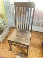 Front view of solid maple chair showing slatted back and contoured seat