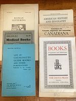 Seven pamphlets laid out showing full covers and titles