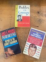 Overview of all three JFK-related paperbacks on table