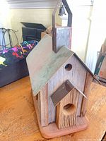 Front and side view of wood birdhouse with copper roof and steeple bell