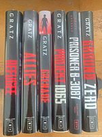 Spine view of all six Alan Gratz hardcover books
