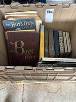 Overview of antique book collection in storage container showing the Boys' Own Annual volumes and other literature.
