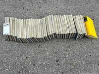 Photo showing all books in the set laid out in a line with visible wear on covers, including fading and yellowing edges
