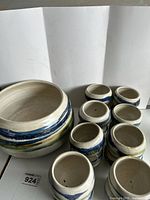Ceramic punch bowl with matching small cups arranged around it