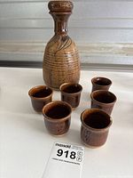 Full set of ceramic sake jug with six cups arranged in front, showing overall condition and size comparison.