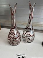 Pair of two matching glass vases displayed side by side showing overall slender shape and brown swirl decoration on clear glass.