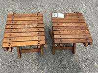 Top view of two wooden collapsible plant stands showing slatted tops and wear marks