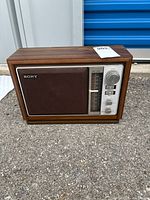 Front view of retro Sony AM/FM radio showing wood grain finish and speaker grille