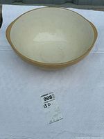 Top down view of the inside of the large beige ceramic mixing bowl, showing discoloration and marks inside the bowl.