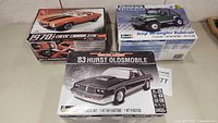 Three car model kits in their original boxes: 1970 Chevy Camaro Z/28, '83 Hurst Oldsmobile, and Jeep Wrangler Rubicon.