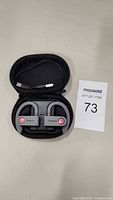 Cobaltx wireless headphones inside a zippered carrying case with USB charging cable visible