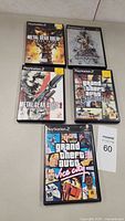 Lot of 5 PlayStation 2 game cases showing front covers including Metal Gear Solid and Grand Theft Auto games.