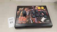 Front view of the arcade fighting stick controller showing Tekken 6 artwork, joystick, and button layout.