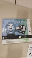 Front of the box showing Snoop Dogg's face and scale details