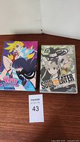 Full view of Soul Eater and Panty & Stockings DVD box sets side by side on a wooden surface.