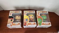 Photo showing the three boxed Funko Pop figures Ryu #137, Ken #138, and Blanka #140 from the Street Fighter series.