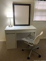 Photo of white desk with lamp, chair with checkered cushion and bulletin board on top