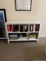 Front view of bookshelf filled with books and some items to show size and shelving layout
