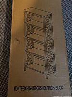 Box showing illustration of Montego high bookshelf in black finish with five shelves and X-pattern on sides.