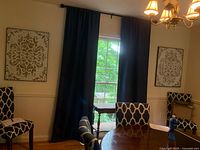 Photo of two beige/off-white rubbed metal 3D wall decor pieces mounted on a wall in a dining room setting, showing scale and placement.