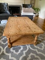 Front angled view showing the coffee table's top surface, legs, and lower shelf with visible wood grain and wear.