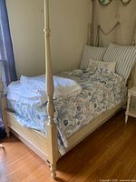 Side view of the vintage four post twin bed showing wood construction, painted finish, and bedding.