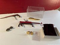 Full lot overview showing two pairs of cufflinks, three multi-tools, packaging and informational card for CSI cufflinks.