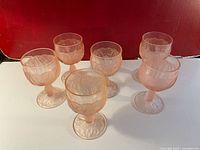 Set of six pink frosted wine goblets on a flat surface showing their shape and design