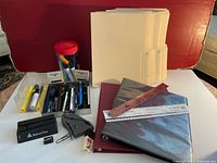 Wide view of lot with file folders, pens, pencils, highlighters, rulers, binders, and stamps
