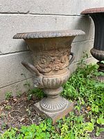 Wide view of entire urn showing flared rim, handles, pedestal base and surface patina