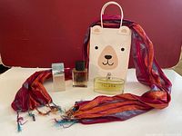 Full set showing three perfume bottles, gift bag, and decorative scarf