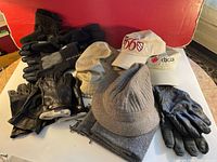 Full lot of men's gloves, hats, and scarf arranged on table showing all included items