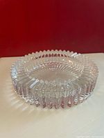 Side angled view showing thickness and detailed faceted edge pattern of clear crystal coaster.