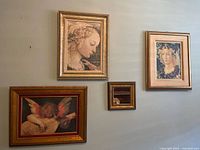 Front view of all 5 items hung on the wall - 4 framed Renaissance style art prints and 1 small framed mirror in wooden frames