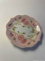Top view showing scalloped edge dish with pink floral pattern and gold accents.