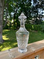 Front view of the Waterford Crystal 13 inch wine decanter with detailed vertical and cross-hatched cut crystal design, outdoors on wood railing.