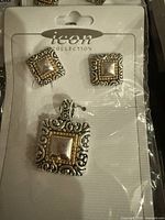 Close-up of one pendant and earring set on card