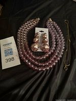 Overall lot: three pink bead necklaces, sequin ball earrings on card, gold-tone chain necklace