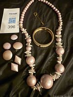 Set laid out showing necklace, bracelet, four clip-on earrings fronts, MaxSold tag