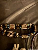 Close-up of gold-tone and black faceted double-strand bracelet
