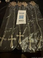 Five individually packaged rhinestone cross necklaces with chains